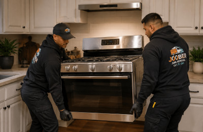 Alt Text: Kitchen appliance removal service with two professionals removing a stainless steel stove
